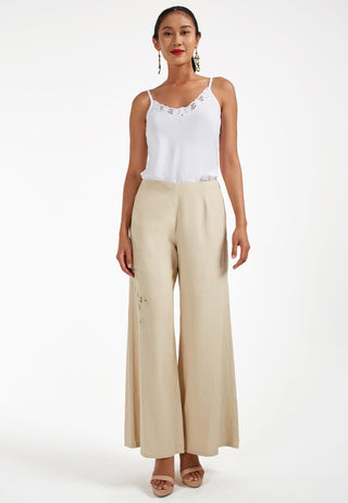Studded with exquisite Balinese handmade lace embroidery on one side of the leg, ARIANA pant. These are loose flared pants made from linen. This pant is beige in colour.