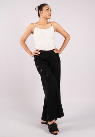 Studded with exquisite Balinese handmade lace embroidery on one side of the leg, ARIANA pant. These are loose flared pants made from linen. This pant is black coloured.