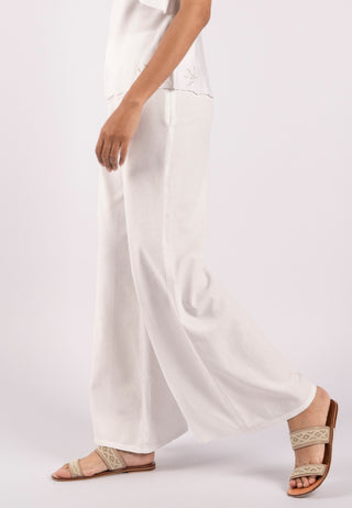 Studded with exquisite Balinese handmade lace embroidery on one side of the leg, ARIANA pant. These are loose flared pants made from linen. This pant is white coloured.