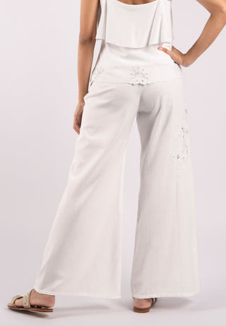 Studded with exquisite Balinese handmade lace embroidery on one side of the leg, ARIANA pant. These are loose flared pants made from linen. This pant is white coloured.