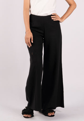 Studded with exquisite Balinese handmade lace embroidery on one side of the leg, ARIANA pant. These are loose flared pants made from linen. Its colour is black.