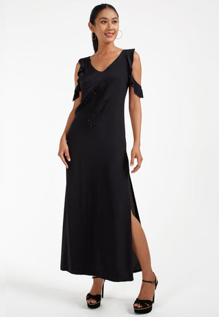Attractive ankle length maxi dress, that has cold shoulder ruffled sleeves and side slit. The intricate Balinese handmade lace embroidery on the mid-riff is too beautiful.  This dress is black coloured.