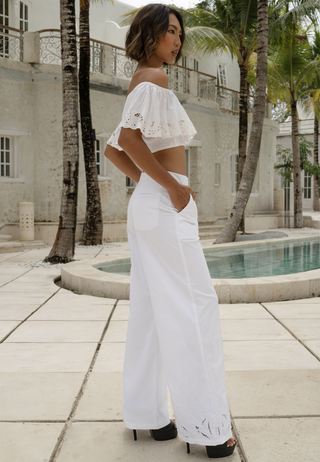 The beautiful girl standing by the pool wearing a gorgeous crop top, golden neck piece, black high heels and comfortable trousers. The loose fitted white pants have Uluwatu’s signature lace work around the hem, it has deep pockets and elasticated waist with zip closure. 