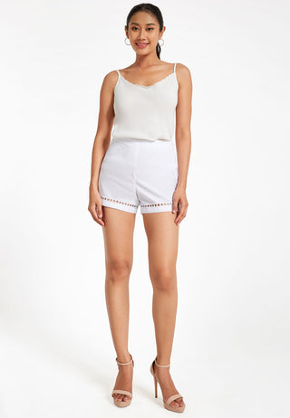 Solid high-rise hot pants for women in pure cotton having schifflili embroidery at the hemline. it has zip closure and deep pockets.